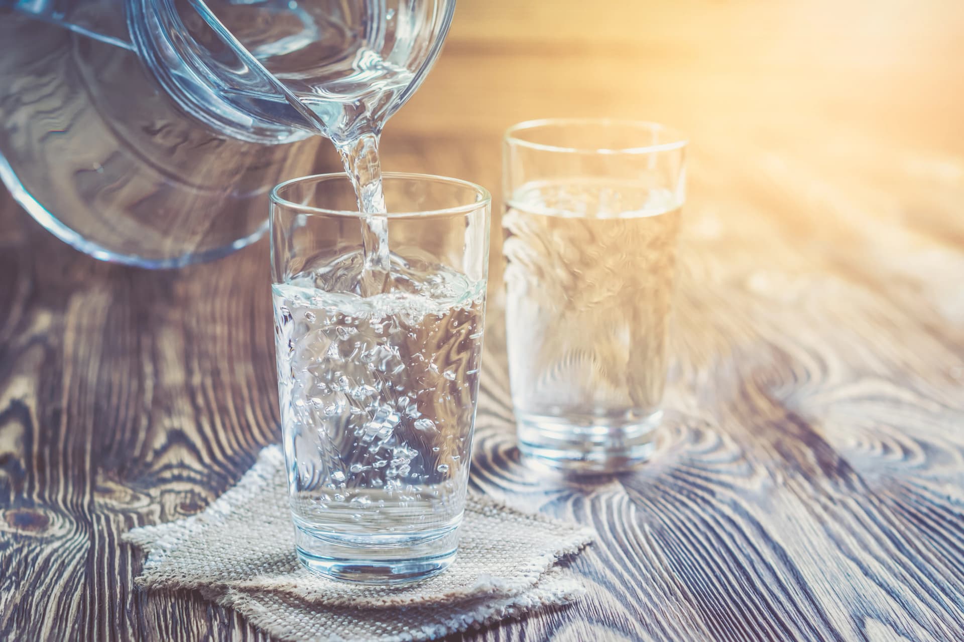 Verres d'eau posés sur une table en bois dans un cadre familial