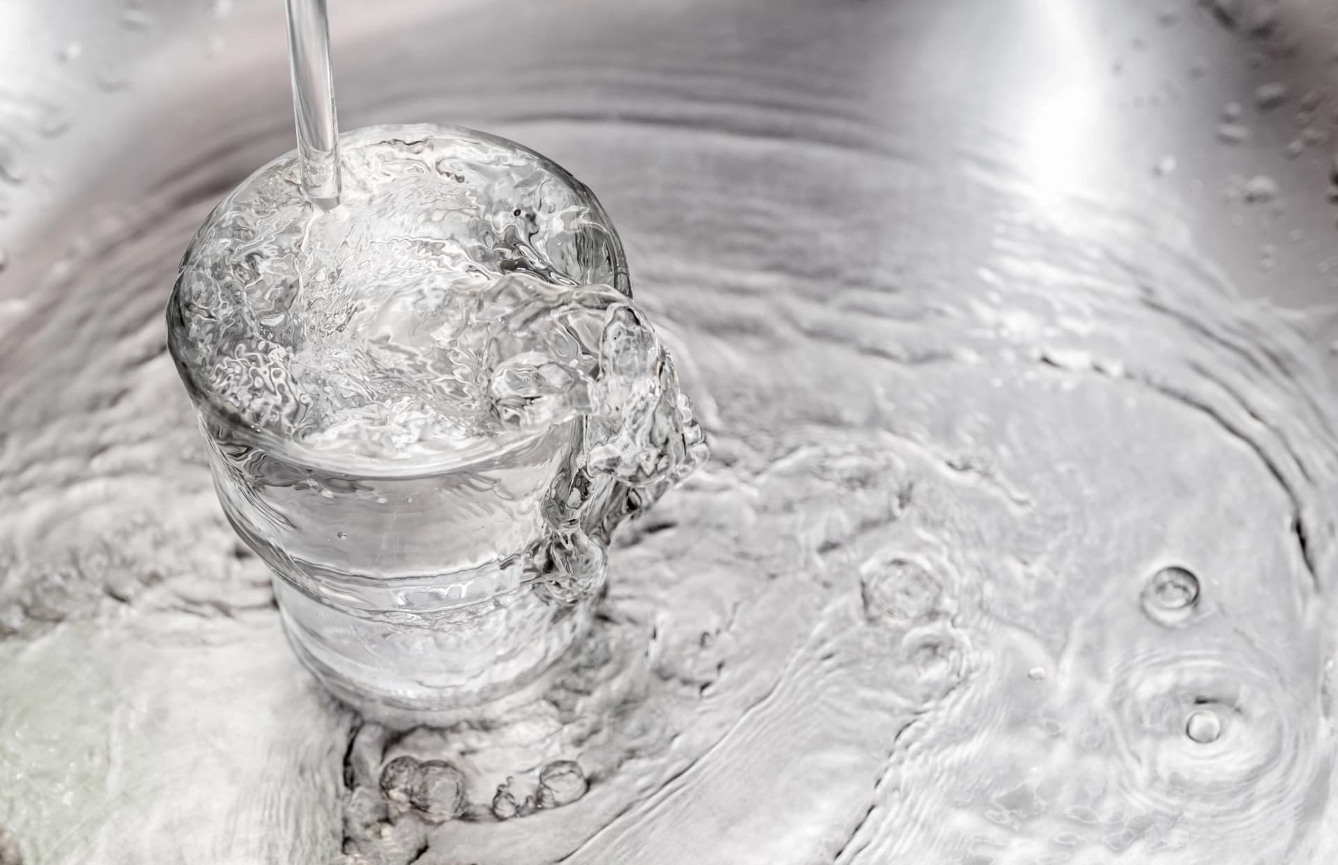Verre d'eau servi au robinet dans une cuisine d'appartement